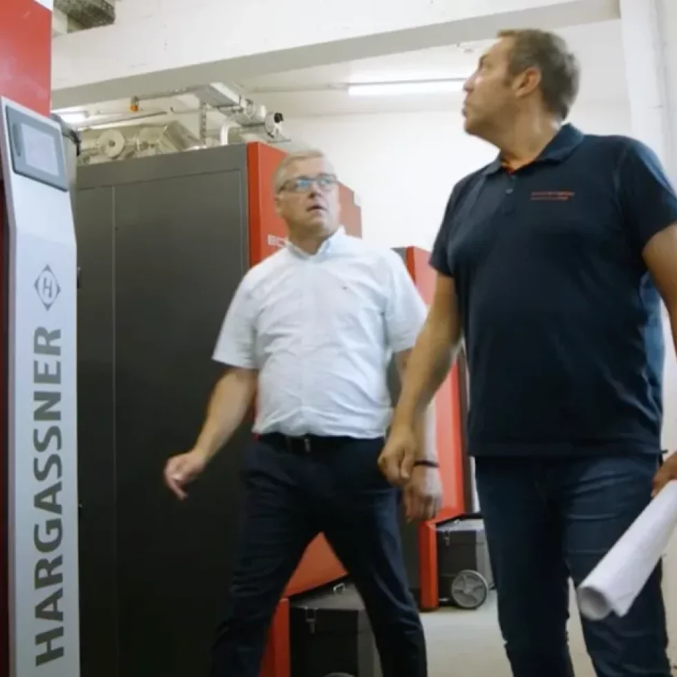 Zwei Personen stehen vor einer Heizanlage