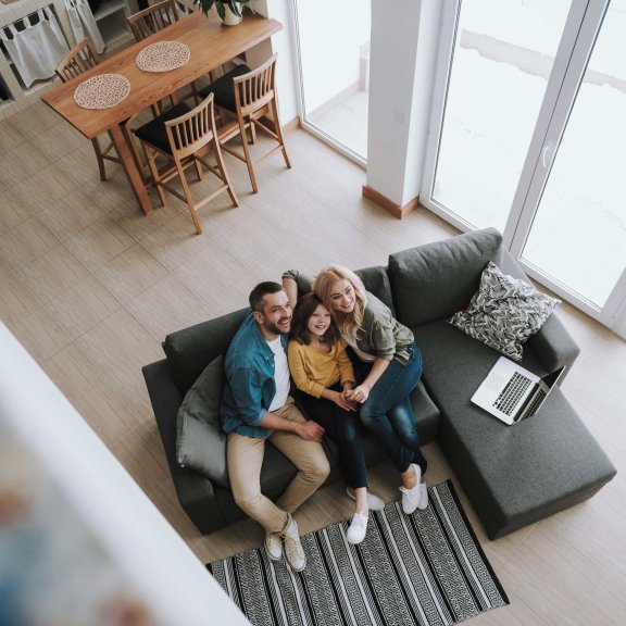 Eine Familie sitzt zusammen auf dem Sofa.