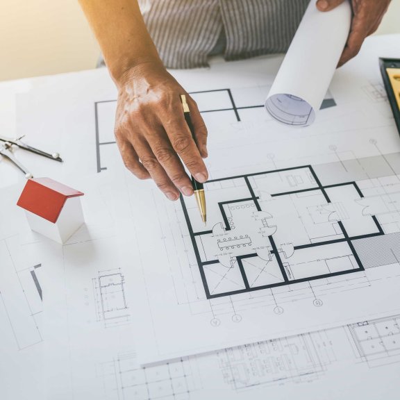 Eine Person schaut sich einen Bauplan genauer an